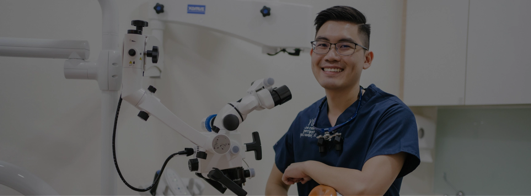 Dentist posing next to cutting edge electronic microscope.