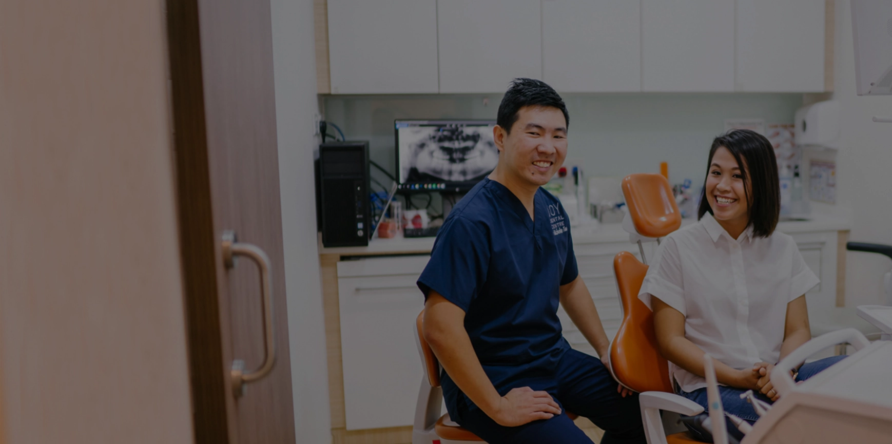 Dentist posing with patient sitting next to him.