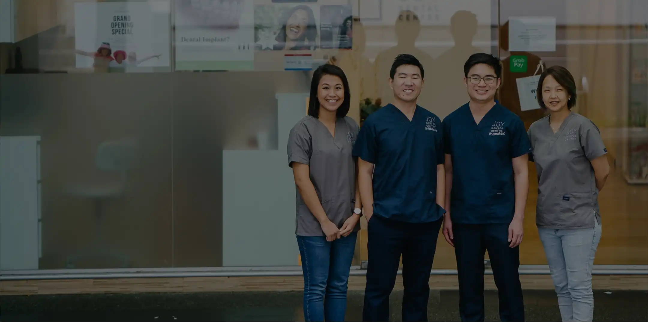 Group portrait: 4 Joy Dental staff in front of the clinic.