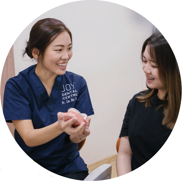 Dentist shows model of braces to patient.