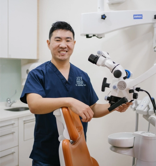 Dentist posing next to cutting edge electronic microscope.