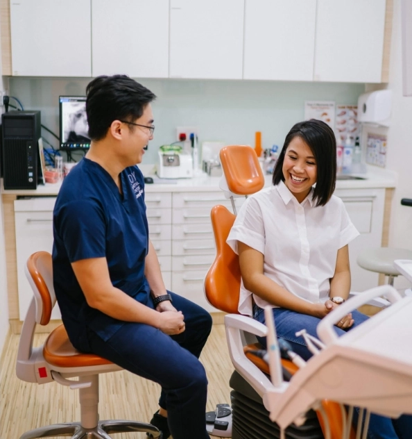 Dentist explaining information to patient sitting in dental chair.