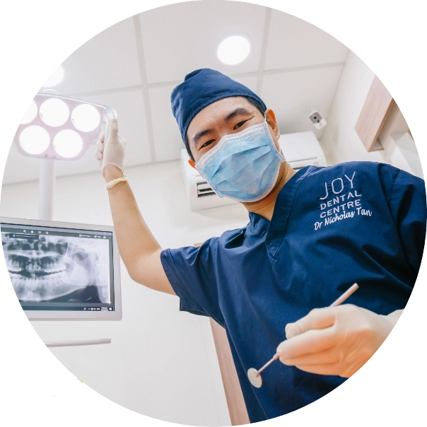 Shot from the patient's perspective, seated in the dentist chair: dentist is adjusting the light and holding his tools in preparation for an examination.