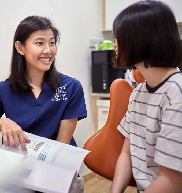 Dentist explaining information to patient sitting in dental chair.