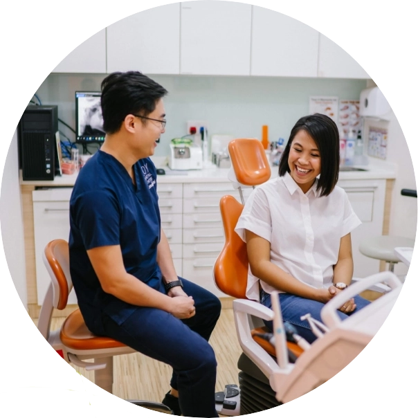 Dentist talking to patient sitting in dental chair.